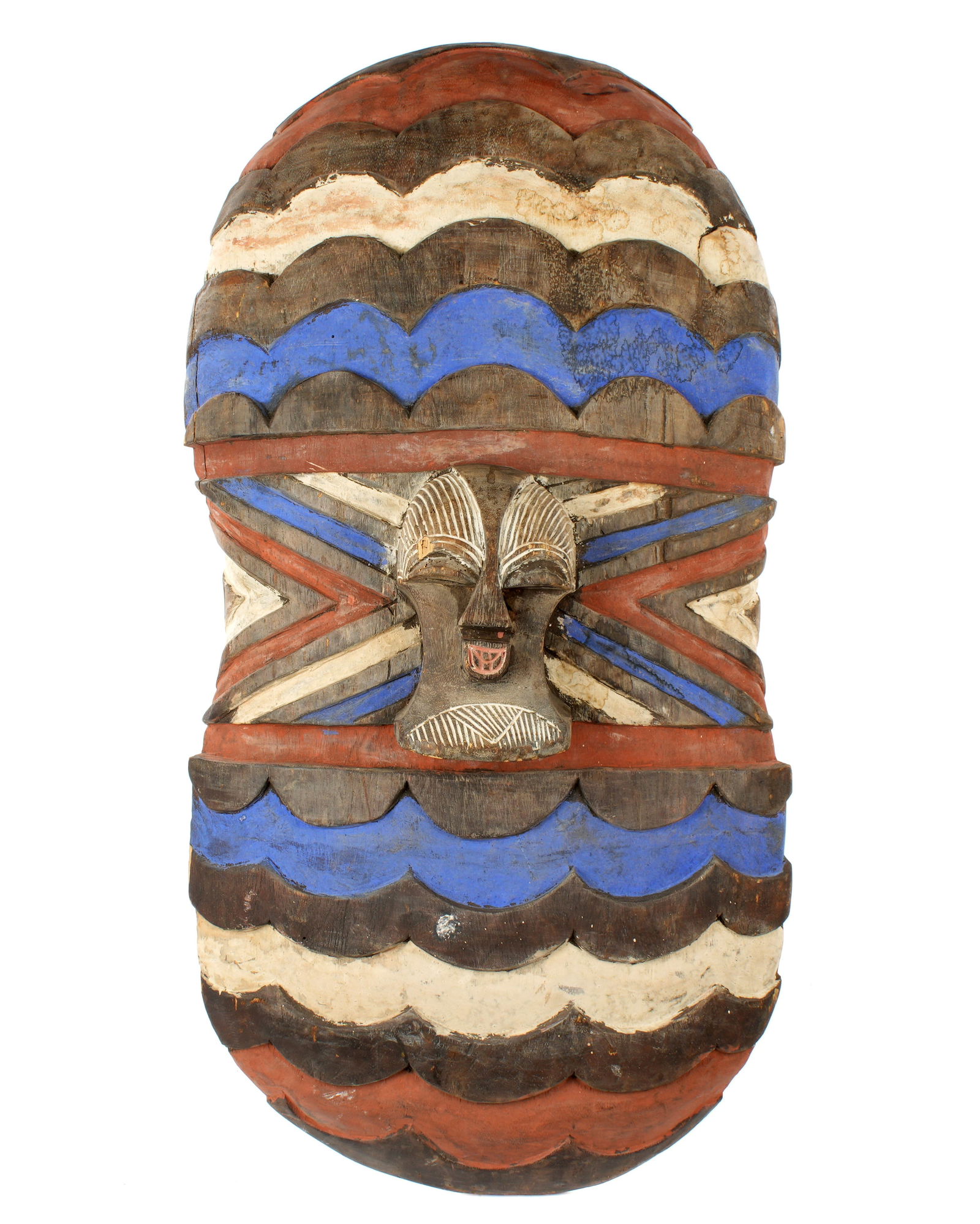 Songye Congo African Carved and Painted Shield: Songye (Songe) tribe, Democratic Republic of the Congo, carved and polychrome decorated mask shield. Overall 38" x 19.75" x 6".