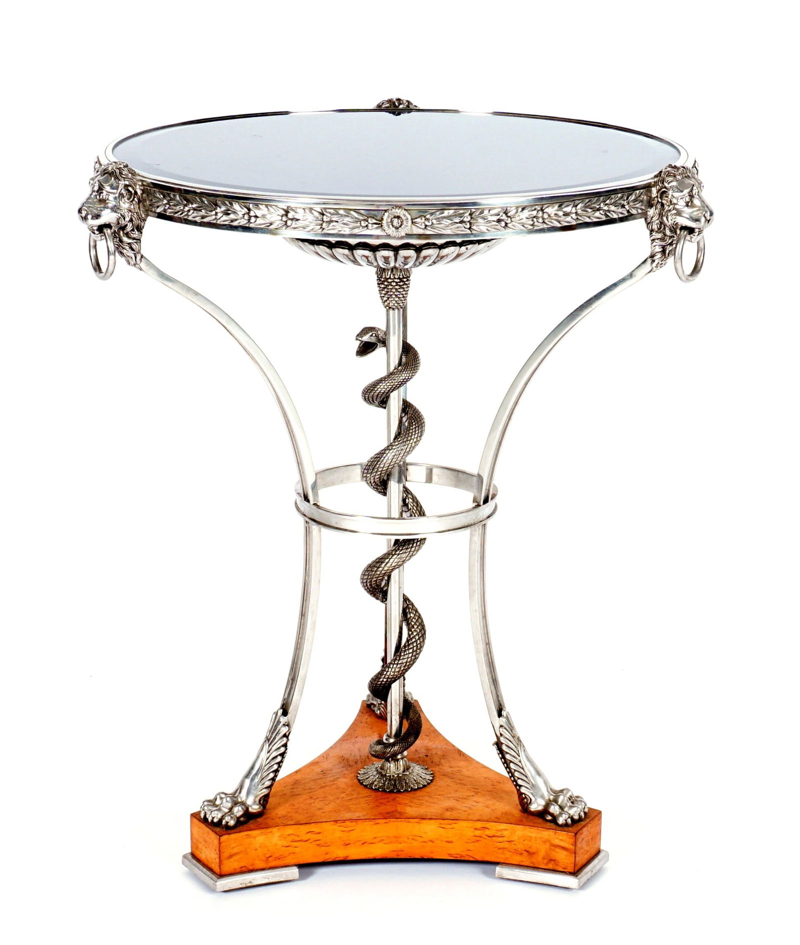 Theodore Alexander Gueridon Side Table: Inset blue acrylic top, nickel finish, top rim with figural lion heads, center support with coiled snake, three shaped legs affixed to splayed wood base on three feet. Overall 28.25" h. x 24". Conditi