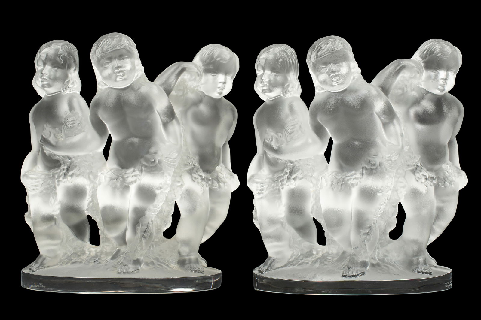 Pair Lalique Crystal Luxembourg Bookends: Pair frosted and molded crystal bookends depicting three putti, signed Lalique, France, 7" x 3.75". No chips or fleabites noted.
