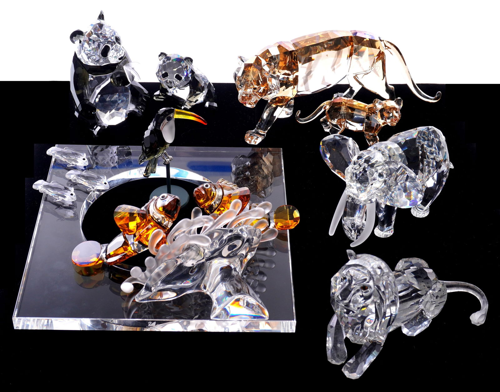 Eight Swarovski Crystal Animals in Boxes: Collection of eight crystal animals, all with original boxes to include amber tiger (7" long), amber tiger cub (3.5" long), lion (5"), elephant (4"), panda (4" h.), panda cub (2.25" h. ), sterling mou