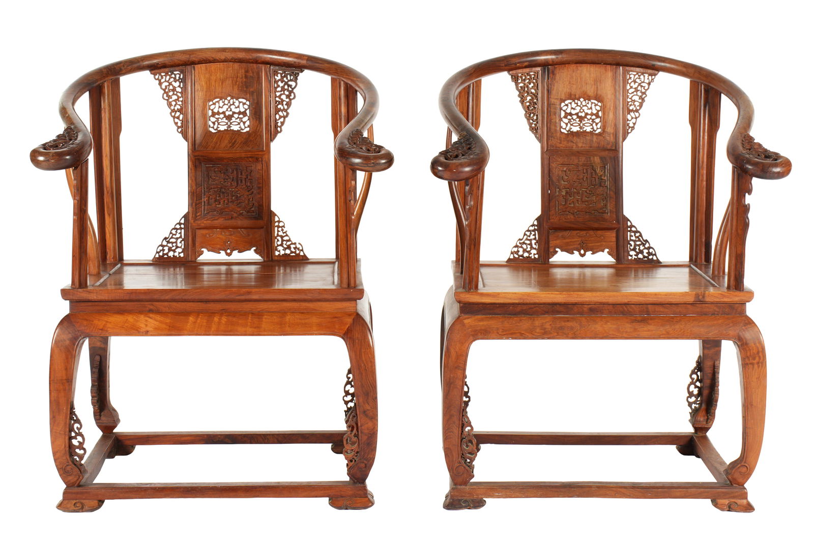 Pair Chinese Horseshoe Back Huanghuali Chairs: 20th Century Chinese Huanghuali or similar wood horseshoe back arm chairs. Shaped top rail extending into arms, reticulated pierced carved accents on back and hand holds. Shaped legs with reticulated
