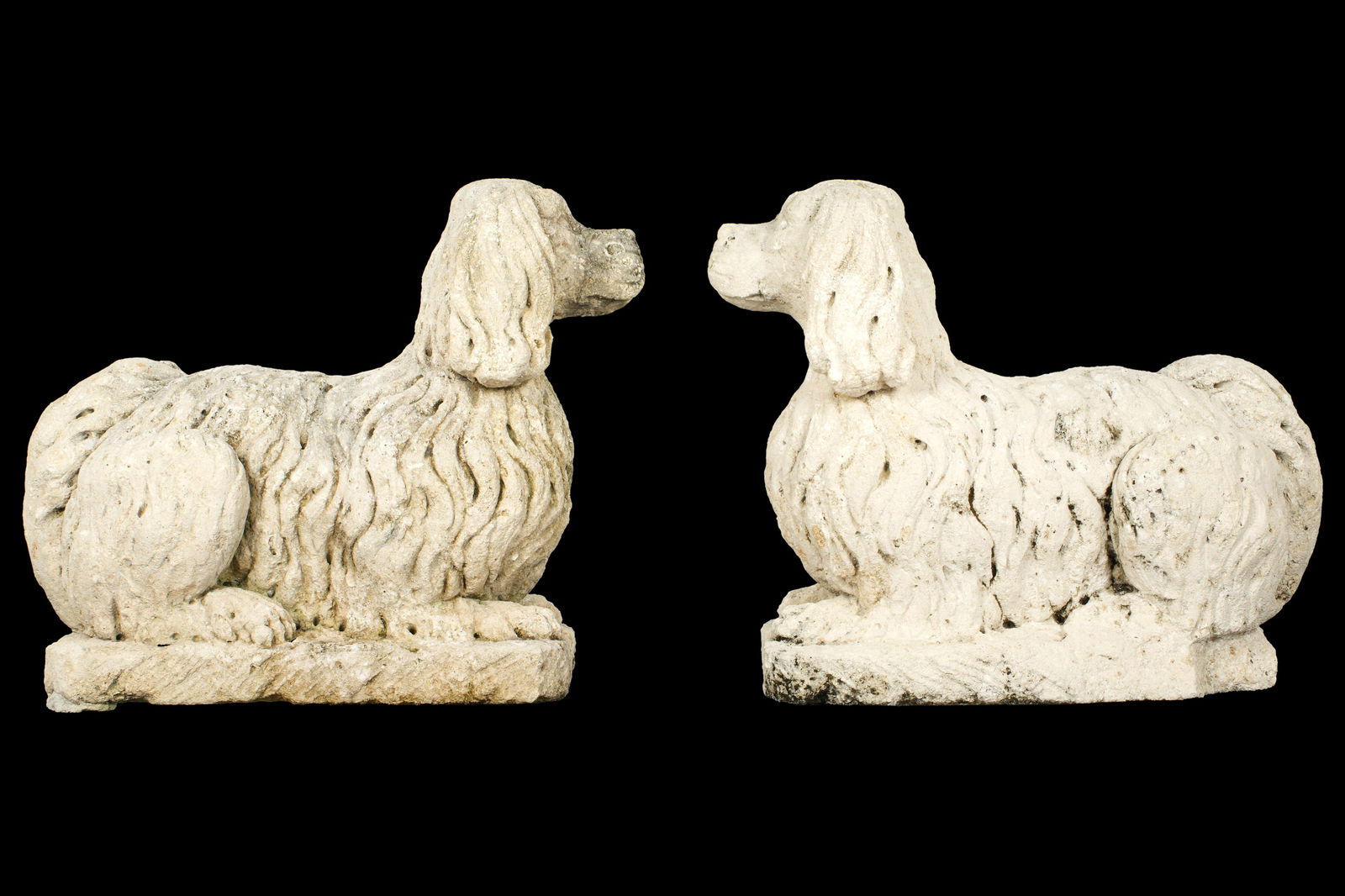 Pair Poured Stone Garden King Charles Spaniel Dogs: Pair poured stone figural King Charles Spaniels, no visible markings. Overall 20" h. x 23" x 10. Condition: Obvious signs of weathering.