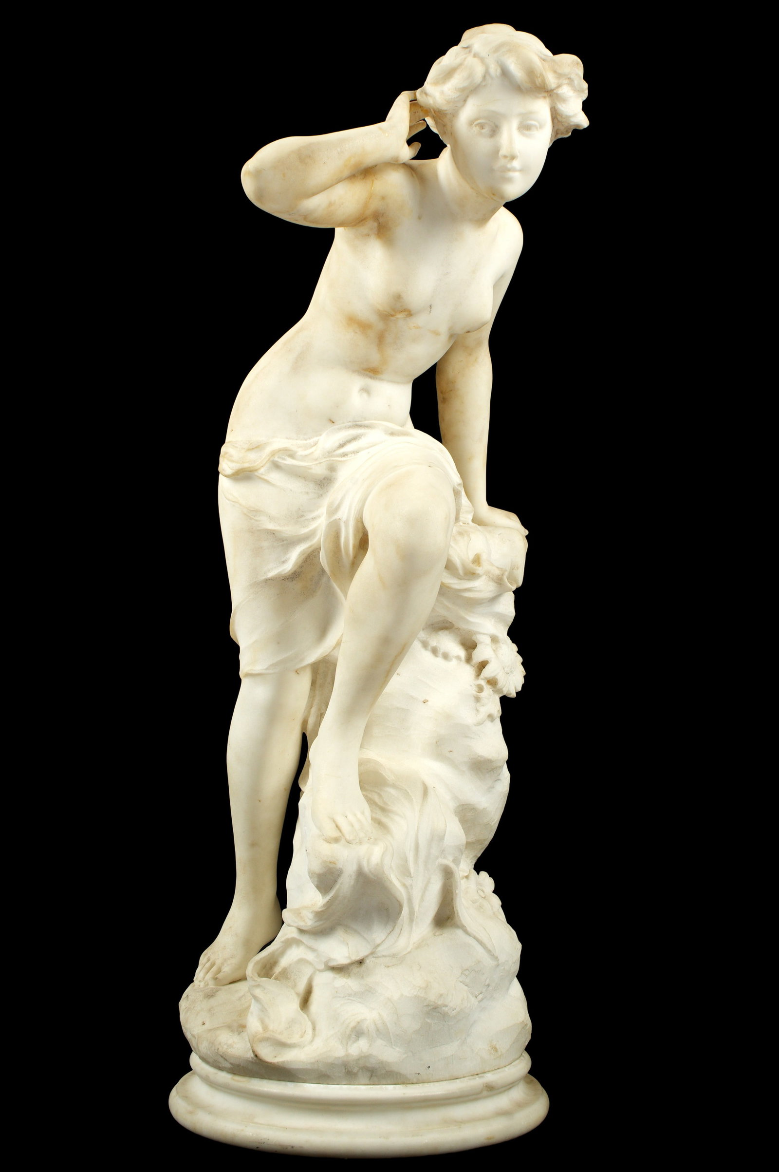 Adolfo Cipriani Carved Marble Semi Nude Maiden: CIPRIANI, Adolfo, (Italian, act. 1880-1930): Carved marble sculpture of a semi nude classical maiden, signed at base. Overall 28.5' h. x 14.5" x 12.5". Sold with marble plinth, 1.5" x 10.5" dia. Condi