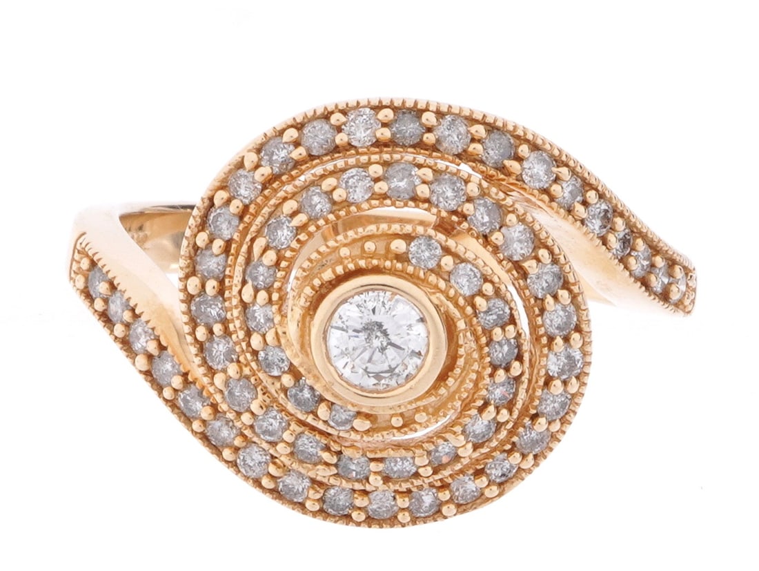 14k Yellow Gold Diamond Swirl Cocktail Ring: Stamped 14k yellow gold swirl design ring, center bezel set approx. .20ct round diamond, approx. 60 prong set accent diamonds on swirl bands. Size 8. Approx. 5.8 grams inclusive.