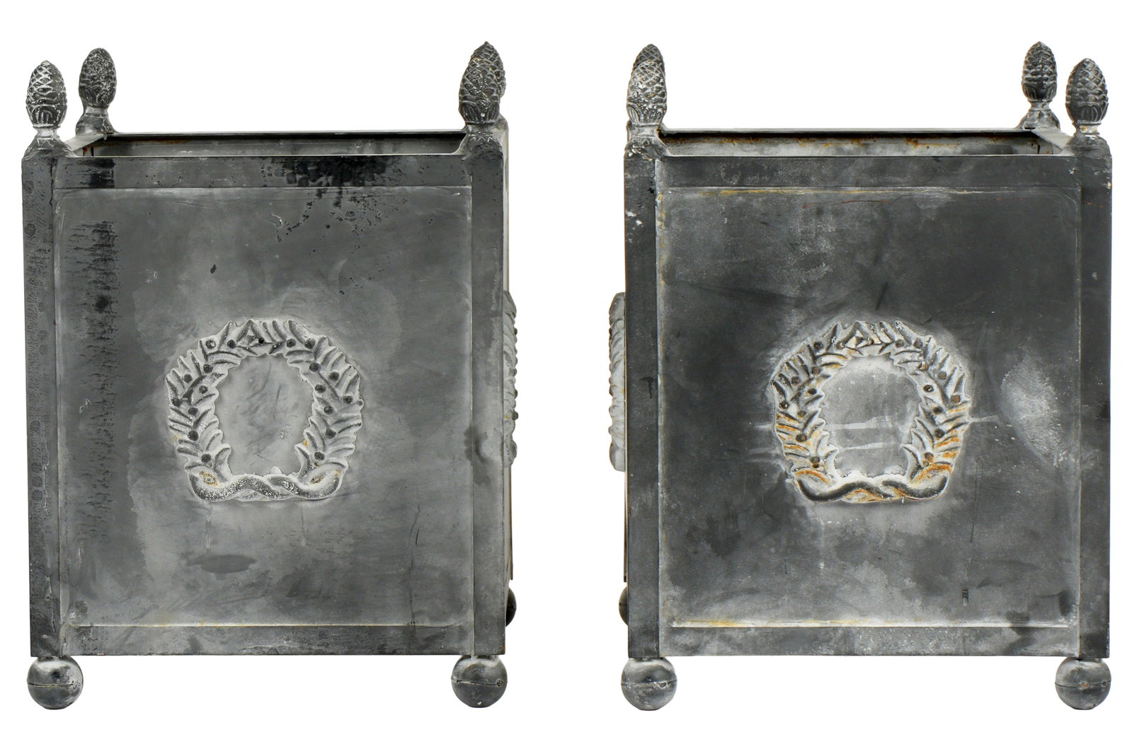 Pair Neoclassical Zinc Grey Garden Planters: Square form zinc garden planters, pineapple finial, raised wreath design on each side, on four feet. Overall 22.5" h. x 16.5" x 16.5". Condition: Signs of weathering.