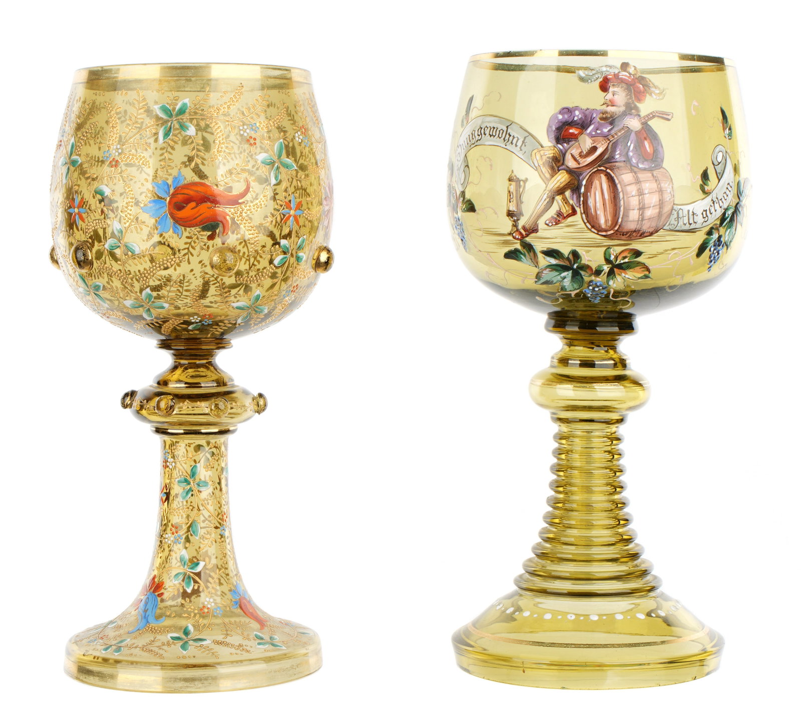 Two German Enameled Green Glass Roemer Goblets: Two pieces total to include 1) Scene of a musician leaning on beer keg with flowers and motto, 11.25" h. x 5". 2) Profuse flowing vines and applied buttons, 11" h. x 4.5". Condition: Minor wear to gil