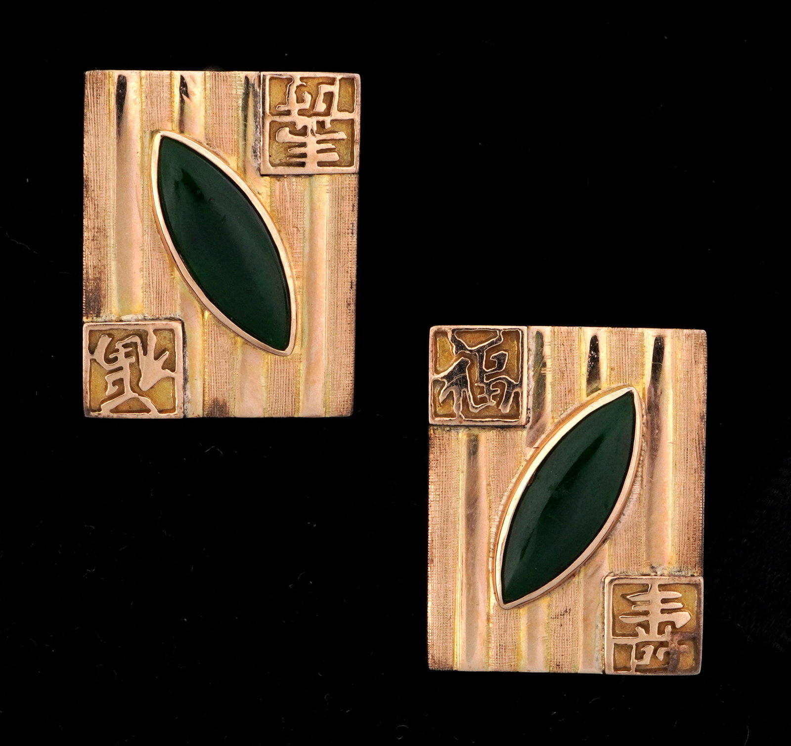 Pair Chinese 14k Gold and Apple Jade Cufflinks: Pair stamped 14k yellow gold cufflink with Chinese character at 2 corners, oval cabochon set green jade or similar stone jade accents, 15mm x 5mm each. Each measures 23mm x 17mm tops. Approx 13.3 gram