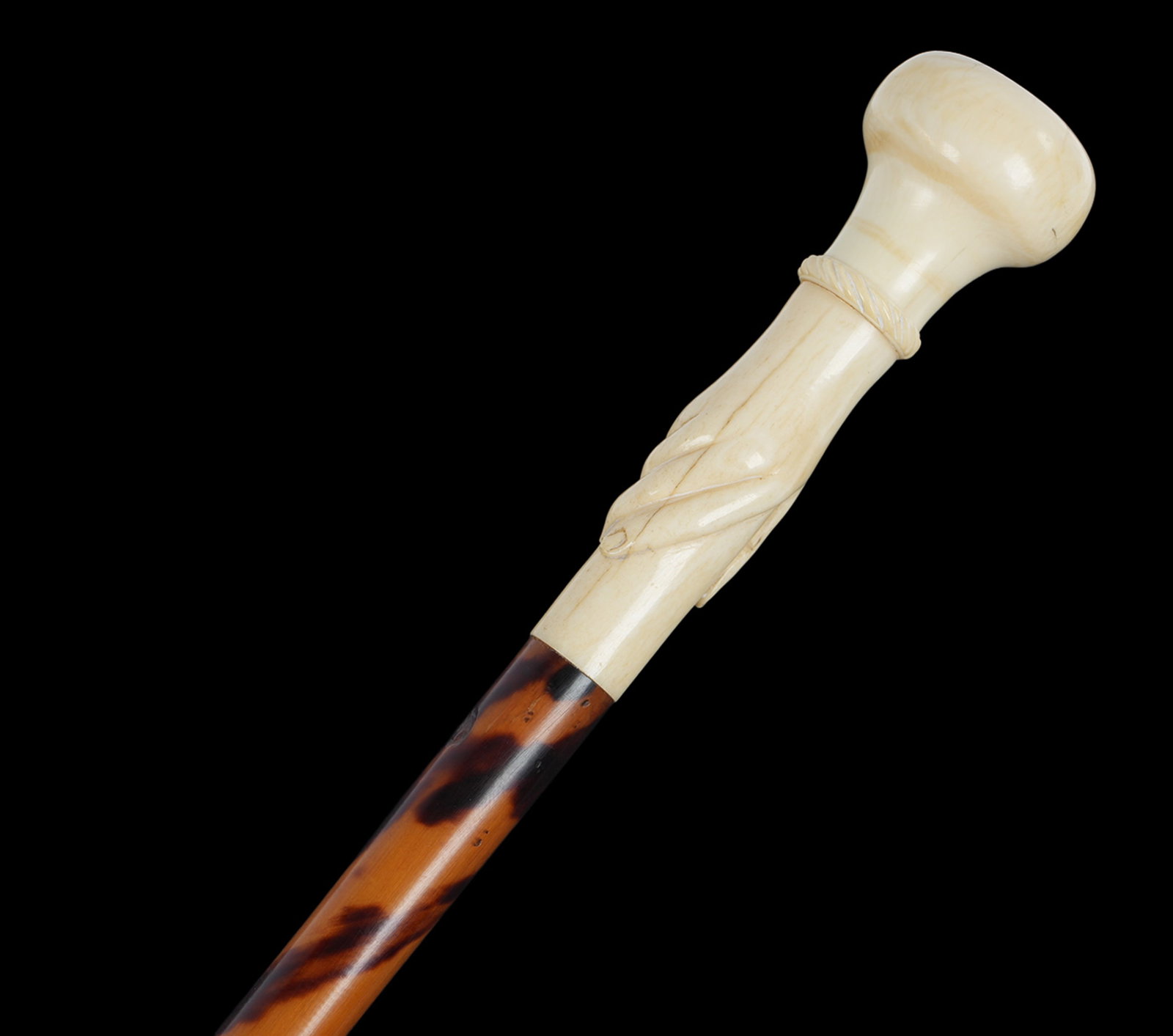 Antique Carved bone Womans Hand Walking Stick: Antique walking stick / cane. Carved bone woman's hand with rope twist bracelet handle. Tortoise clad shaft, metal tip. Overall 37.75" long. THIS LOT CANNOT BE SHIPPED OUTSIDE THE STATE OF FLORIDA.