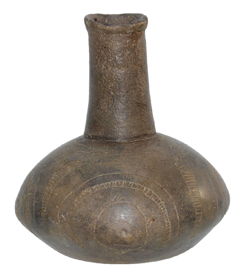 6" H. Engraved Caddo "Pillow" Bottle. Pictured: 6" H. Engraved Caddo "Pillow" Bottle. Nicely squared shape with detailed engraving. AR. Small chip glued on rim, neck may be glued. Very good condition. Pictured in Art of the Ancient Caddo, p158.