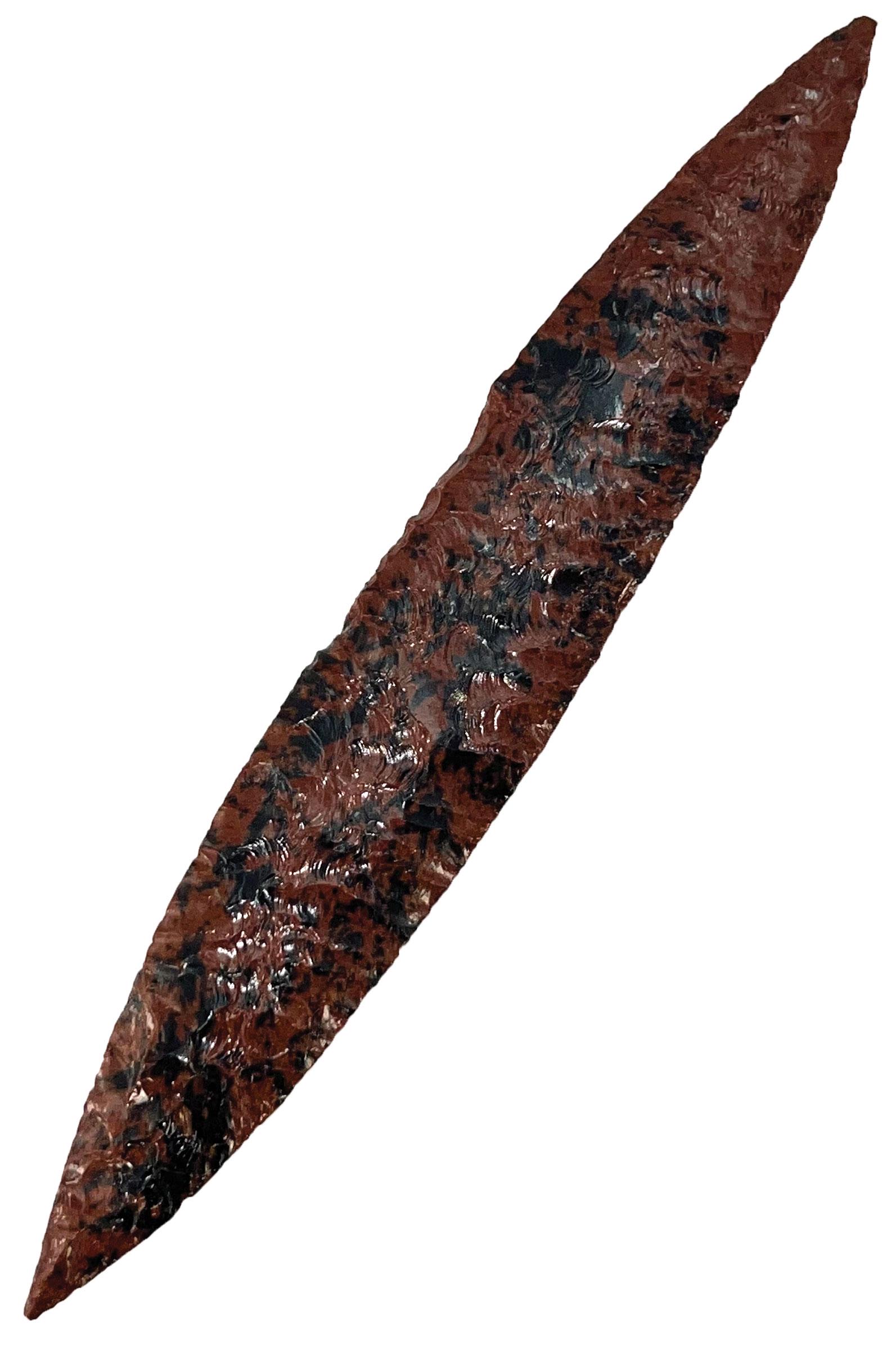 9 1/2" Mayan Bi-Point Blade. Mahogany Obsidian. Pictured in Who's Who: 9 1/2" Mayan Bi-Point Blade. MX. Pre-Columbian. Made out of Mahogany Obsidian. Masterful lateral flaking. G10. Part of a large cache found in Colima, MX near the Naranjo River. Acquired by George and