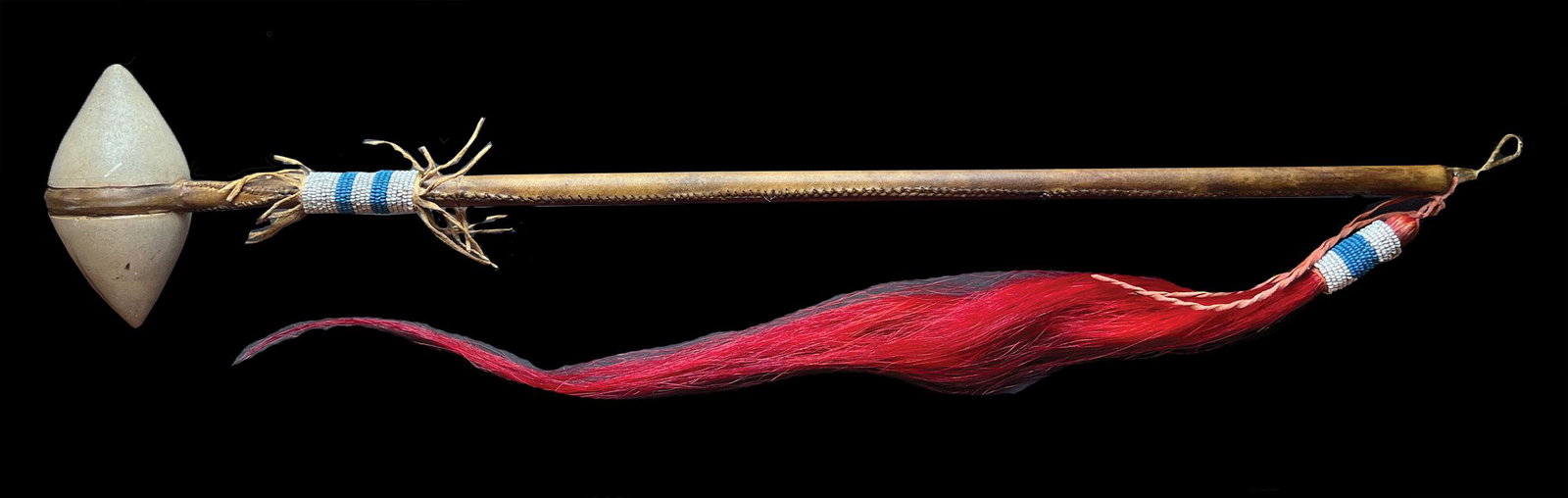24" Head Knocker. Polished stone head, beautifully leather wrapped handle. Tourist trade: 24" Head Knocker. Polished stone head, beautifully leather wrapped handle. 16" red "horse hair" decoration. Shaft decorated with blue and while seed beads. Excellent early tourist trade (~100 years ol