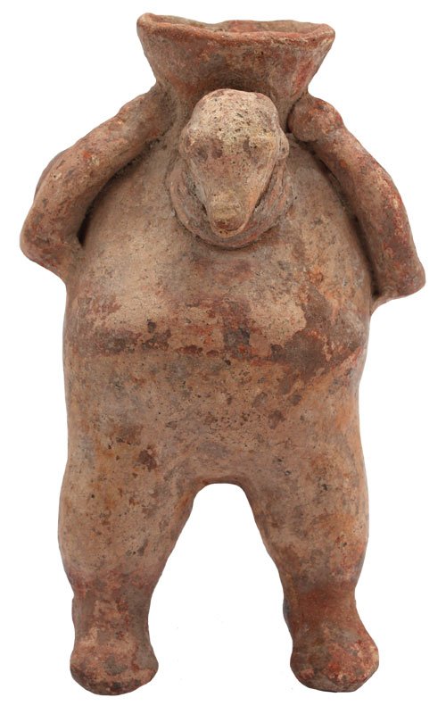 5" Modeled creamware standing anthropomorphic effigy: 5" Modeled creamware standing anthropomorphic effigy with a dog's head on the upper section. Long legs; arms holding head; flat open mouth on top of vessel. In poor condition. Colima, MX. 250 BC to 25