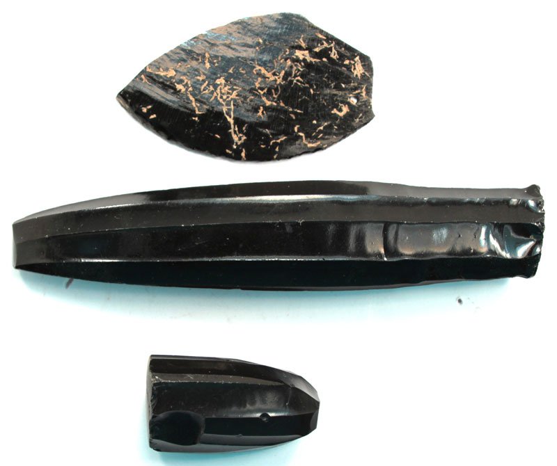 3 Obsidian Artifacts: 2 Obsidian Cores remaining from Bladelet manufacture (2" and 6 1/2"). One Obsidian Flat Face Obsidian Knife with worked cutting edge. Appears to have been drilled for suspension (3 1/4"). All are Pre-