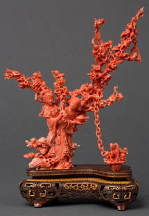 A CHINESE CARVED CORAL FIGURAL GROUP: Fine carved coral figural group with two women, an intricate tree with many blossoms, and a basket of flowers attached to a chain. Mounted on a chased wood base. Figures are fixed to the base, the bas