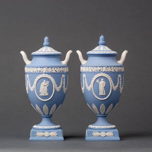 A PAIR OF WEDGWOOD JASPERWARE COVERED URNS: A pair of fine Jasperware covered urns, Wedgwod blue ground with medallions featuring the muses Tepischore - with the harp - and Thalia - with the dramatic mask - respectively. Both post 1970 stamped