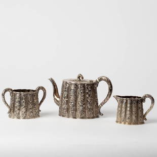 LATE 19TH CENTURY CHINESE EXPORT TEA SET: All silver plated with embossed vertical panels, includes a 5 x 8 inch teapot, 3.5 x 5.5 inch sugar, and 3.25 x 4.5 inch creamer. Unmarked.