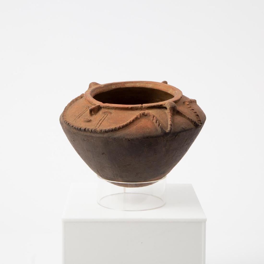 A PRE-COLUMBIAN NARINO CULTURE VASE: Pre-Columbian Narino culture (Colombia, ca. 850-1250 CE). Terracotta vase with high relief serpentine rope-like trim around two weeping faces with slit eyes, raised noses and slit mouths. Snakes often