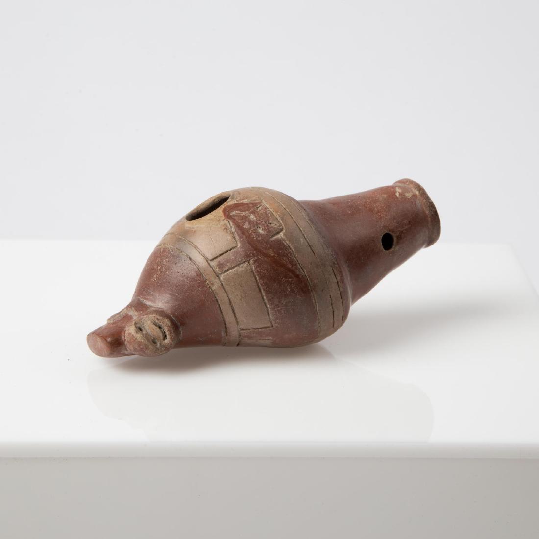 A NARINO CEREMONIAL OCARINA VESSEL FLUTE: Pre-Columbian Narino culture (Colombia, ca. 850-1250 CE). A brown and red terracotta ocarina vessel flute with stylizied animals around the circumference and monkey face at the top. Measures 4.75 inch