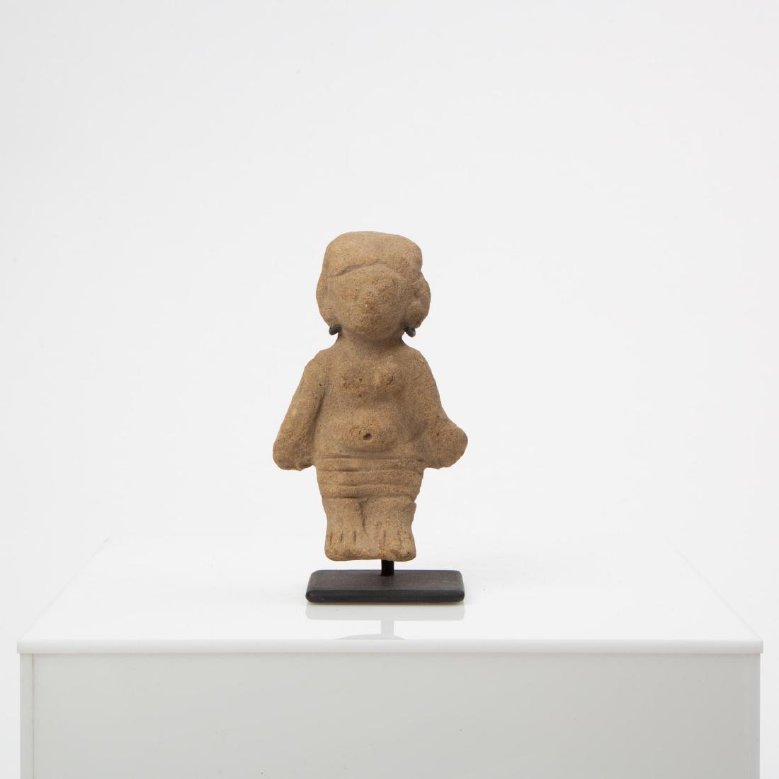 A PRE-COLUMBIAN SINU OR TUMACO DEITY EFFIGY FIGURE: A fine carved effigy figure with a slightly hydrocephalic head, protruding belly, and horizontally striped waist cloth. Measures 5 x 3 inches.