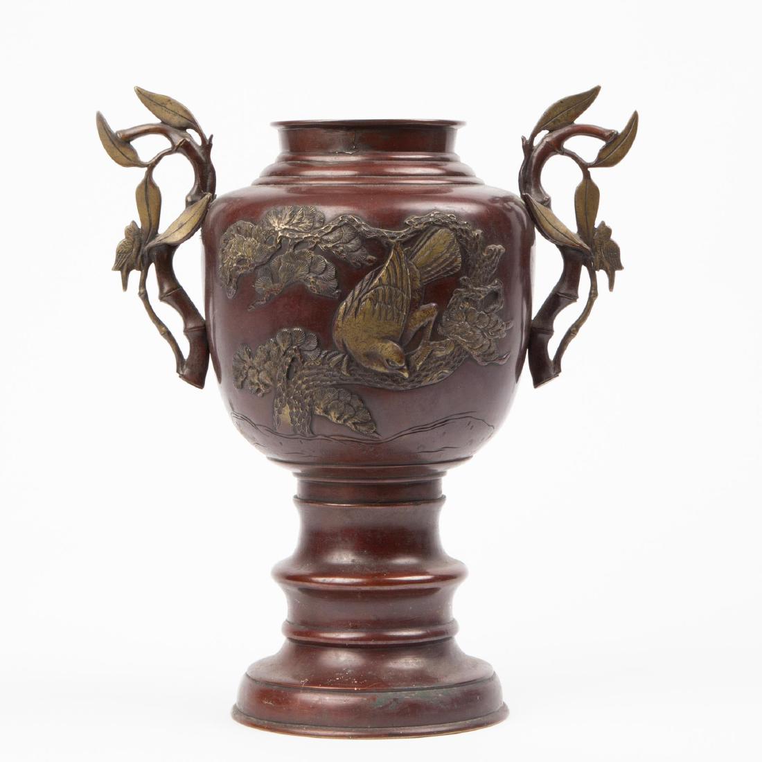 JAPANESE BRONZE VASE, MEIJI OR TAISHO PERIOD: Japanese bronze vase on a stem foot, decorated with bird and pine tree motifs in relief and two bamboo-shaped handles to the body. Base unmark. Measures 13 inches high.