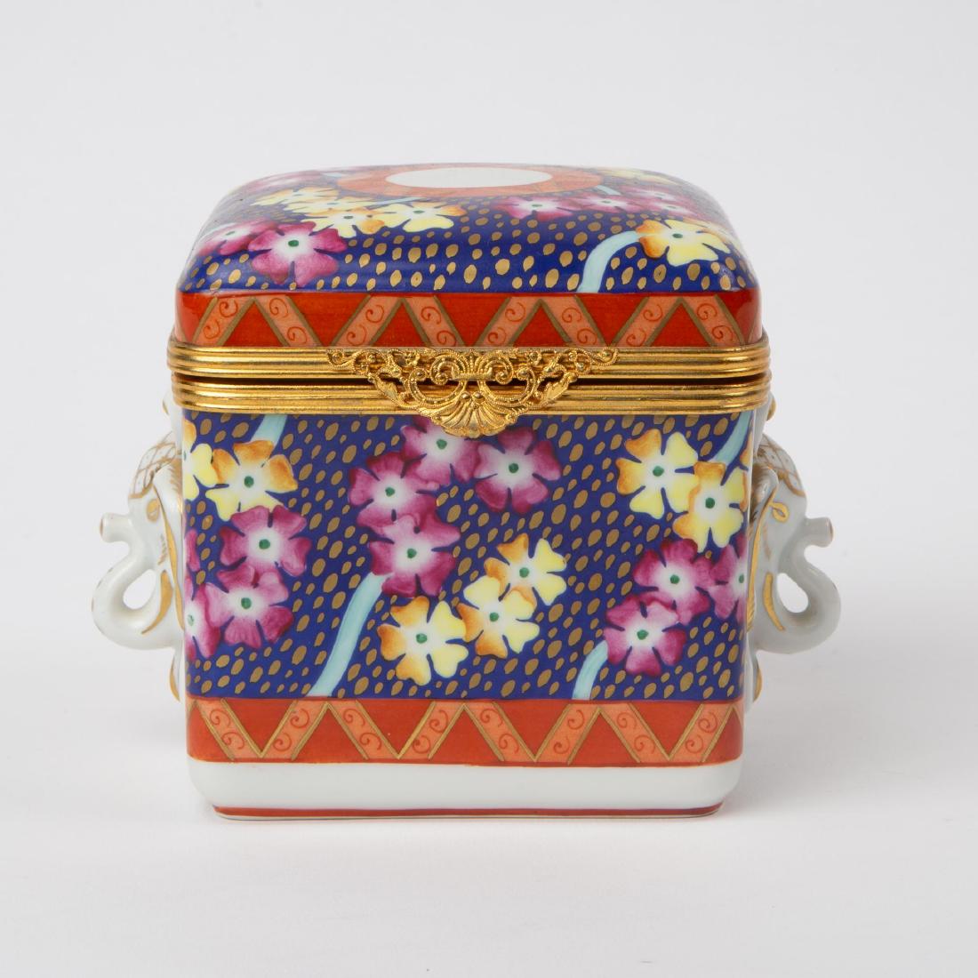 LE TALLEC FOR TIFFANY & CO. PORCELAIN BOX: An Atelier Le TallecÂ hand-painted Limoges porcelain box for Tiffany & Co., with gilt metal hinged rim. The box is hand-painted with flowers on a cobalt ground, and from two sides protrude a gilt el