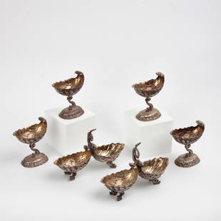 Six Silver Dolphin and Shell Tableware Items: Four silver-plated master salt cellars and two condiment servers, all in the form of cockle shells and Florentine dolphins, comprising a finely cast six-piece matching set. Unmarked, circa 1900,