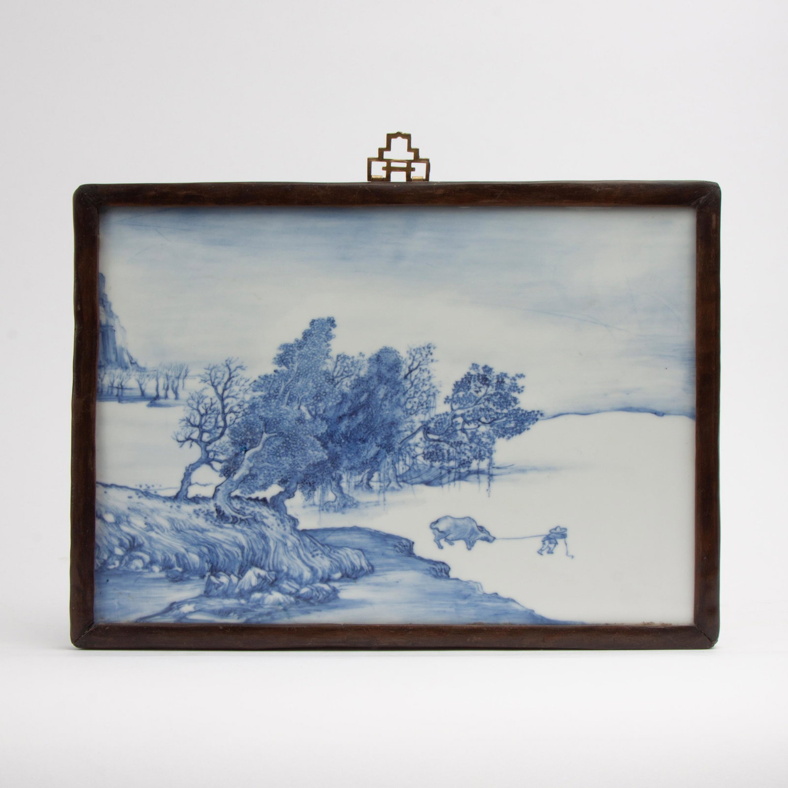 Chinese Painted Porcelain Plaque in Rosewood Frame: An antique Chinese blue and white porcelain plaque, beautifully hand-painted with a scene of a farmer pulling a water buffalo past a grove of trees. In a handcrafted period rosewood frame with ru