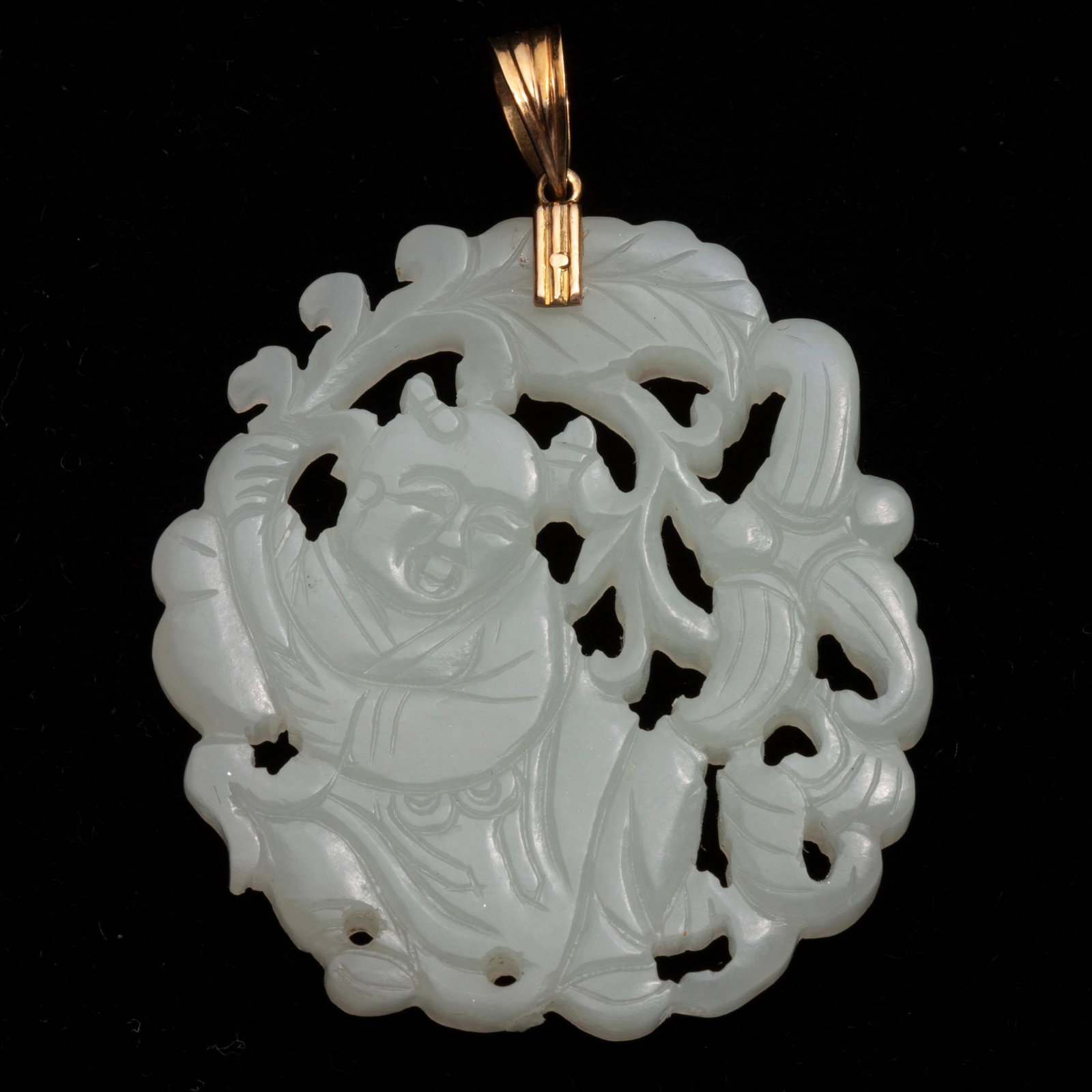 Jadeite Jade Carved Pendant Of Boy w/ Banana Leaf, 14k: Jadeite jade carved pendant with 14k yellow gold bale. The pendant shows a boy holding a long, curved banana leaf that surrounds his body, a motif symbolizing one being able to safeguard one