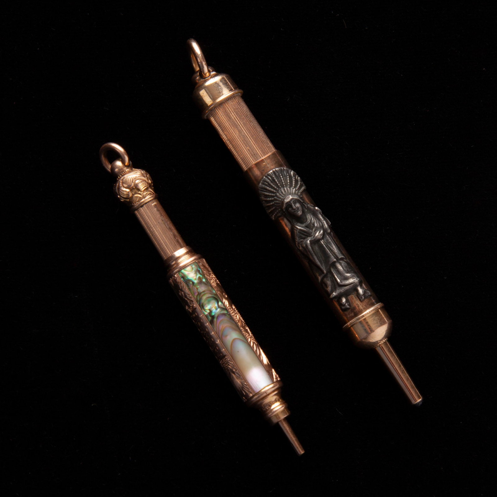 Group of 2 Pencil Pendants, Aikin Lambert Co, and: Group of two telescoping retractable pencil pendants. The first is by Aikin Lambert Co and depicts two figures, one s a figure with a star above his head, the second figure is wearing a