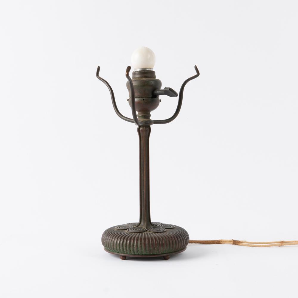 Tiffany Studios Bronze Boudoir Lamp: A bronze Tiffany Studios boudoir lamp, circa 1910. Original Bryant switch, three spiders, ribbed shaft terminating in six fiddlehead fern coils atop a reeded base, all standing on five small ball