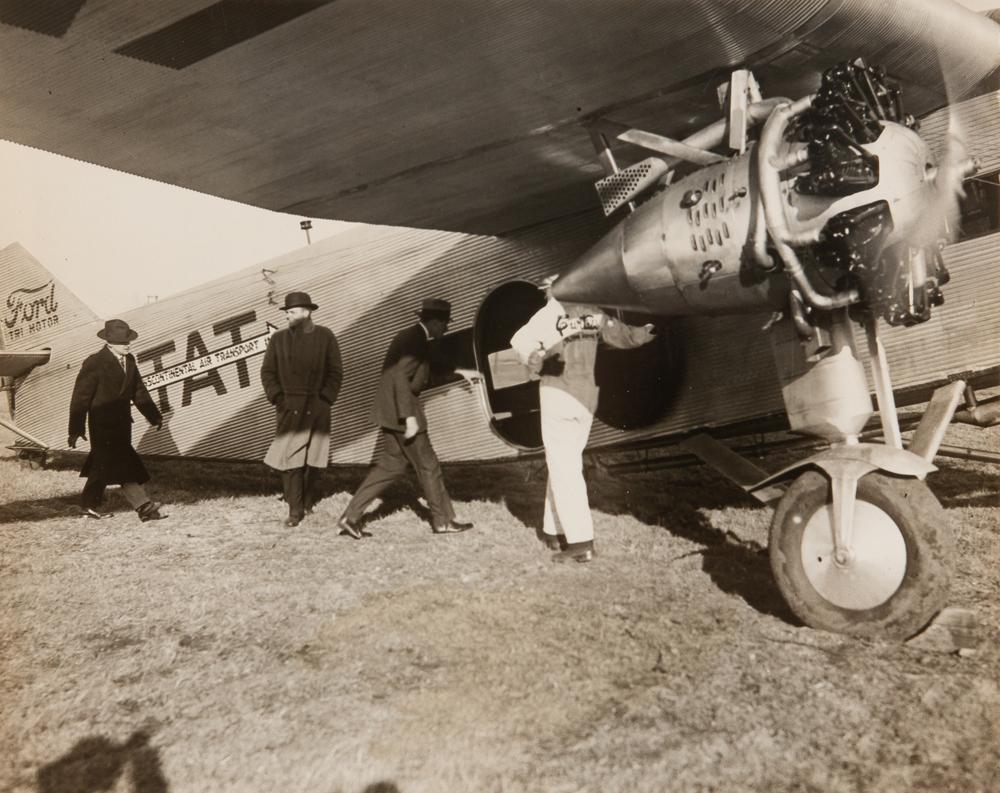 1929 Charles Lindberg T-A-T Aviation Photograph: A 1929 silver gelatin print of legendary aviator Charles Lindbergh, as he enters a Ford Tri-Motor plane, helping to begin the short-lived operation of Transcontinental Air Transport. Ti