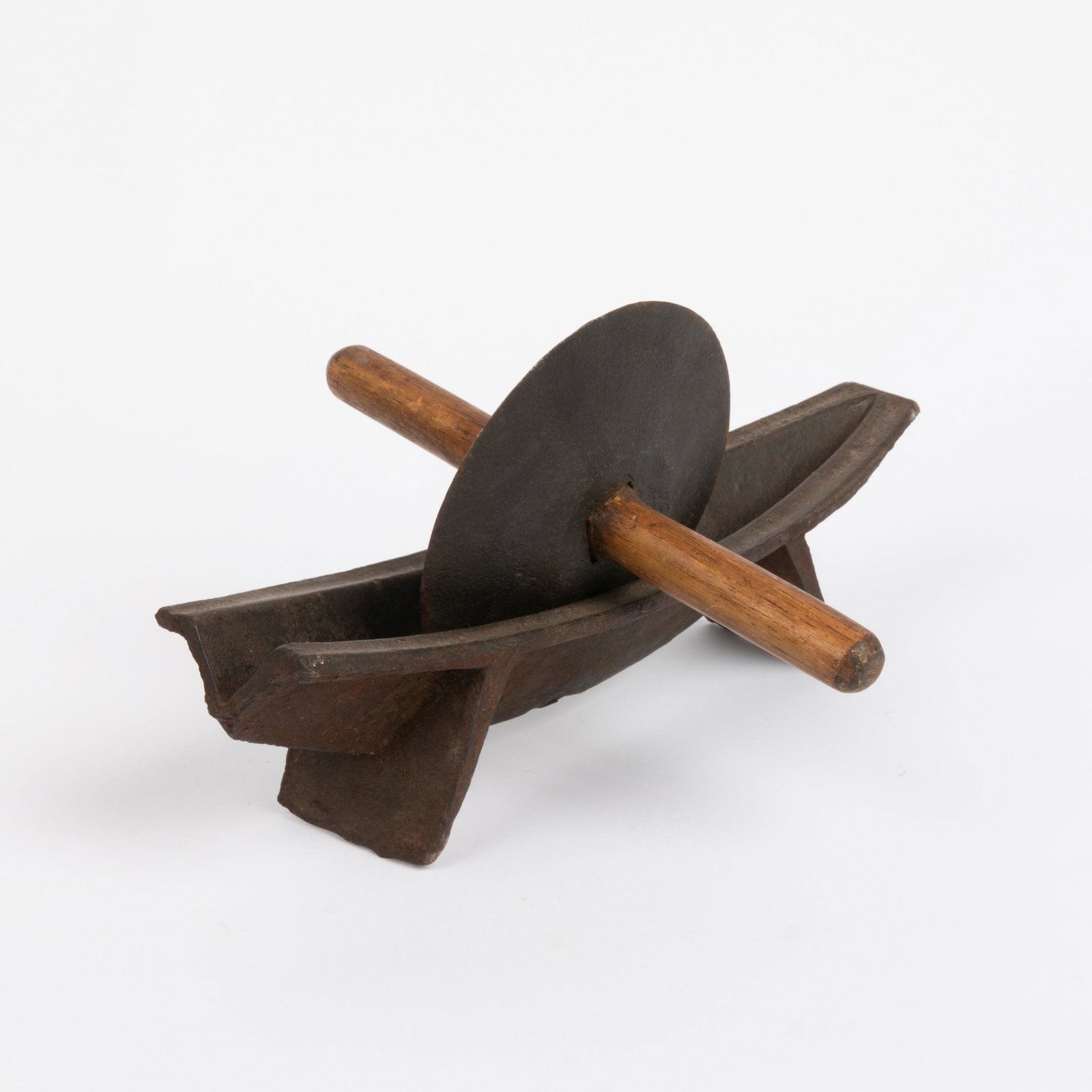 Iron Herb Grinder, Early 19th c.: A primitive iron herb grinder, early 19th century. Boat form cradle with splayed feet and flat rim, and an iron wheel blade with carved oak handle. Attached to one side of the cradle is an illegi