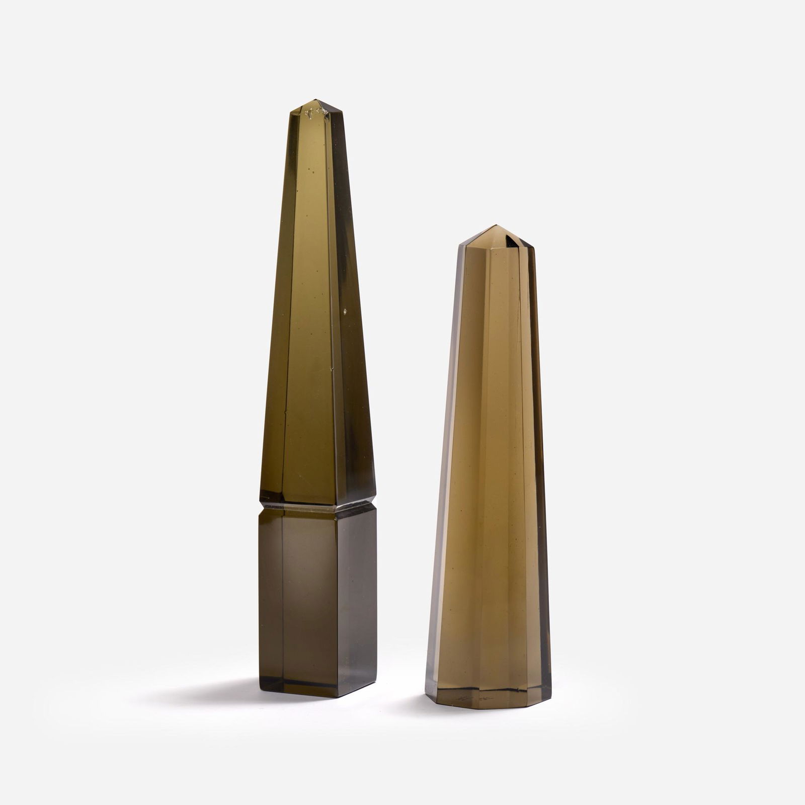 Pair of Venini Glass Obelisks: Two vintage Venini smoked glass obelisks, the taller having a square base and the shorter having an octagonal base. The taller is marked with a "Venini Murano Italia" acid stamp to the undersi