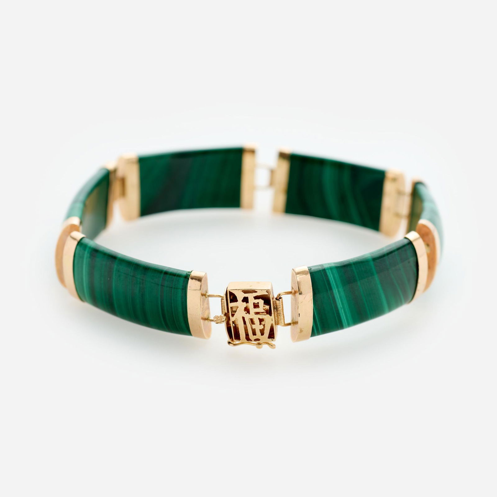 14k Malachite "Lucky" Link Bracelet: A 14k yellow gold and malachite link bracelet comprised of six malachite panels capped with gold articulating links and finished with a box clasp containing the Chinese symbol for "Lucky". Di