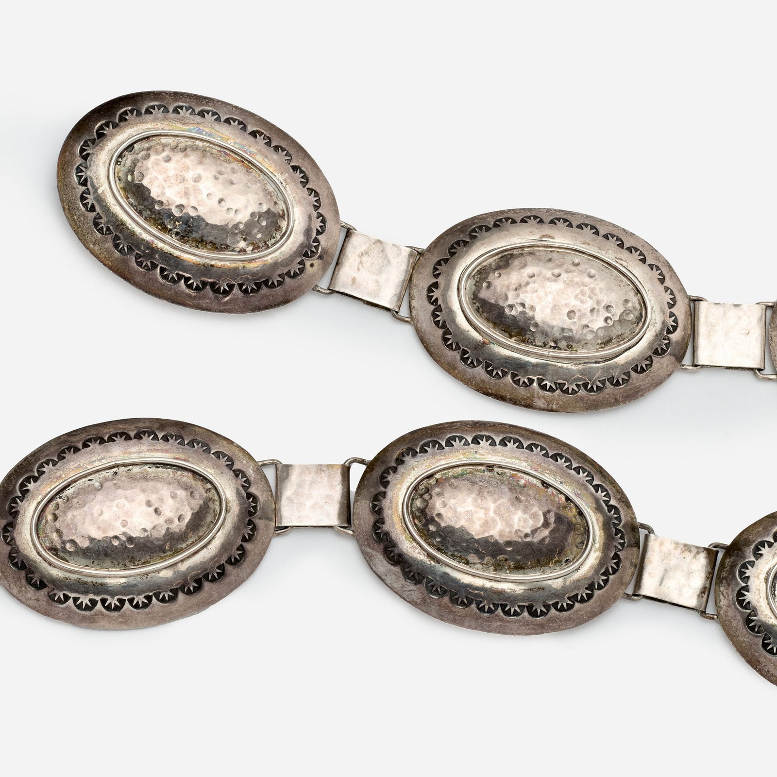 Navajo Sterling Concho Link Belt by Mike Thomas: Mike Thomas (Navajo) A sterling concho link belt by Navajo artist Mike Thomas consisting of sixteen hammered oval concho links with stamp work borders linked together with a hammered square link. Clas