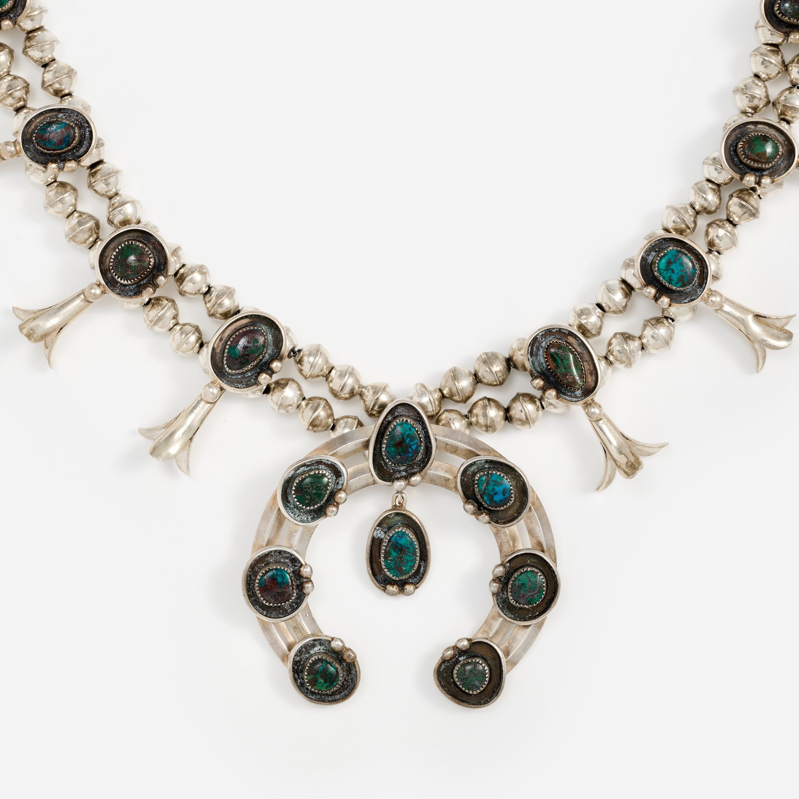 Dan Chee Navajo Sterling Turquoise Squash Blossom Necklace, Handcrafted: A Dan Chee Navajo handmade sterling and turquoise squash blossom necklace with a double strand of handmade sterling beads, twelve blossoms and naja each set with a turquoise in a shadowbox w