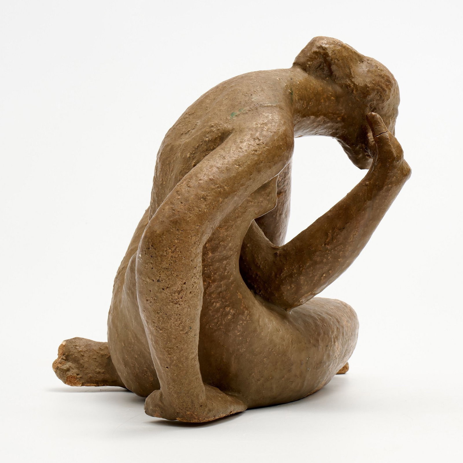 Glazed Stoneware Figure: A glazed stoneware female figure, an elongated nude in slumped posture. Not signed. Measures 10" x 11" x 9".