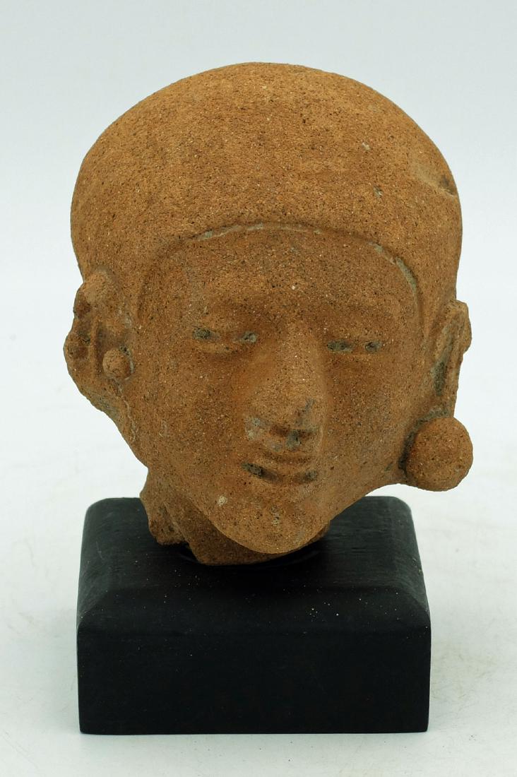 LaTolita Head - Ecuador, ca. 400 BC - 500 AD: An exceptional LaTolita head from Ecuador, ca. 400 BC - 500 AD. This large example is 3.5" high and depicts an individual with the characteristic elongated head. He is adorned with ear and nose orname