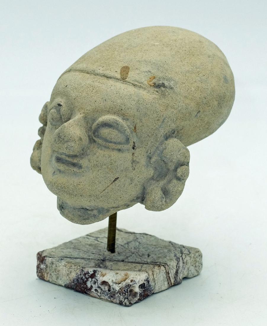 LaTolita Head - Ecuador, ca. 400 BC - 500 AD: An exceptional LaTolita head from Ecuador, ca. 400 BC - 500 AD. This large example is 4" long and depicts an individual with the characteristic elongated head. He is adorned with ear and nose ornament