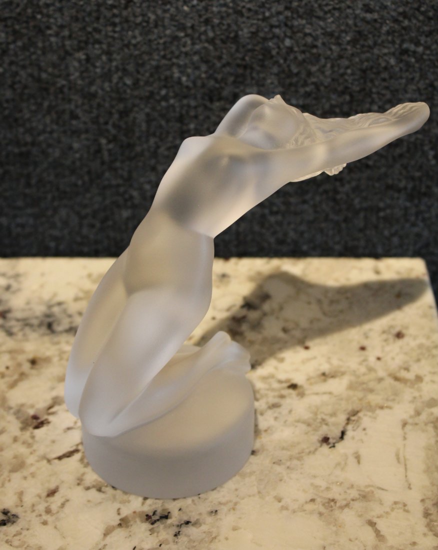Lalique Crystal "Chrysis" Female Nude Figurine: Signed 'Lalique France' on base. This Lalique female nude is made to appear swept up by the wind, with gracefully arched back and flowing hair. This figurine is inspired by those designs, with the thr