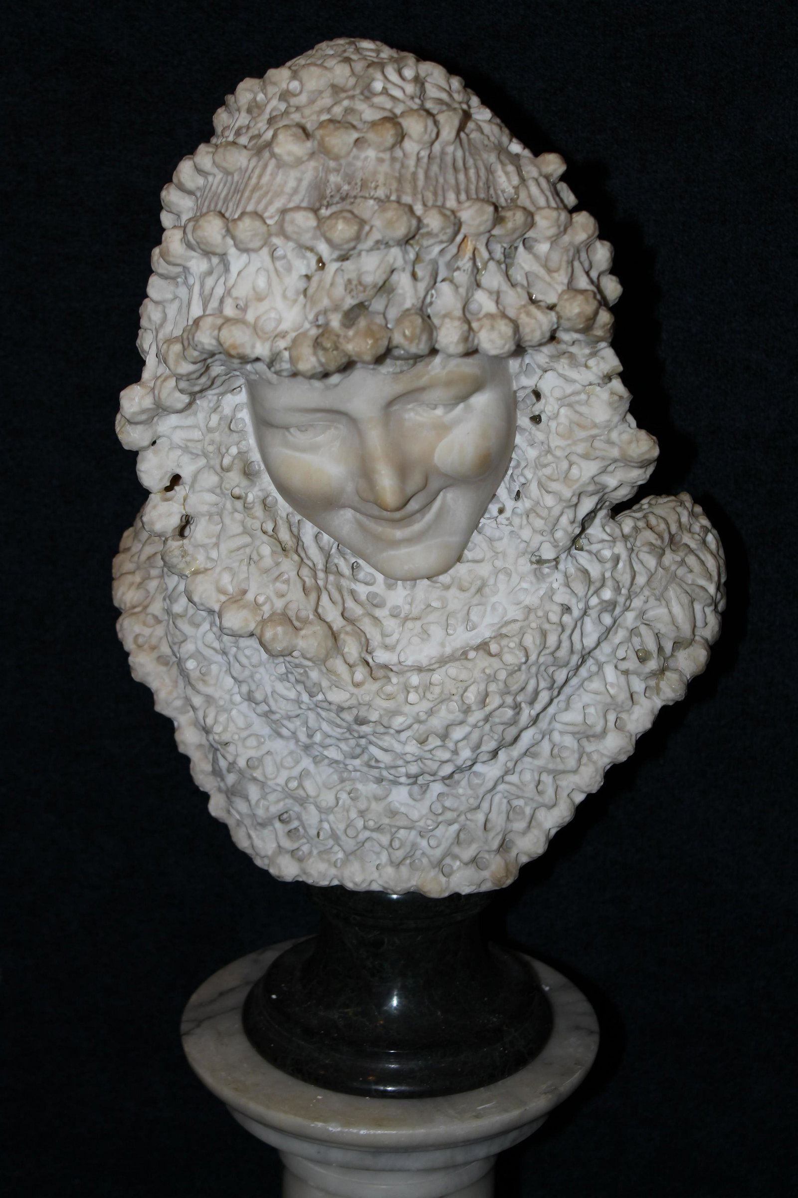 Carved Alabaster Bust of a Woman on Marble Base: Carved Alabaster Bust of a Woman on Marble Base. Having area of restoration above right eyebrow. Total Height (Including Base): 20 inches.