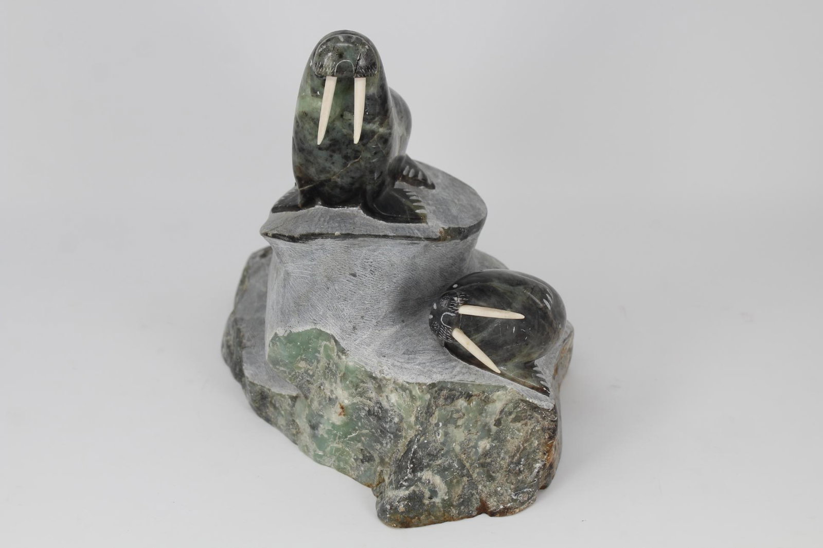 J Tobuk Inuit Carved Walrus Sculpture: J Tobuk Inuit Carved Walrus Sculpture. Walrus having bone tusks. Signed near base. Dimensions: 8.75 x 11 x 7 in.