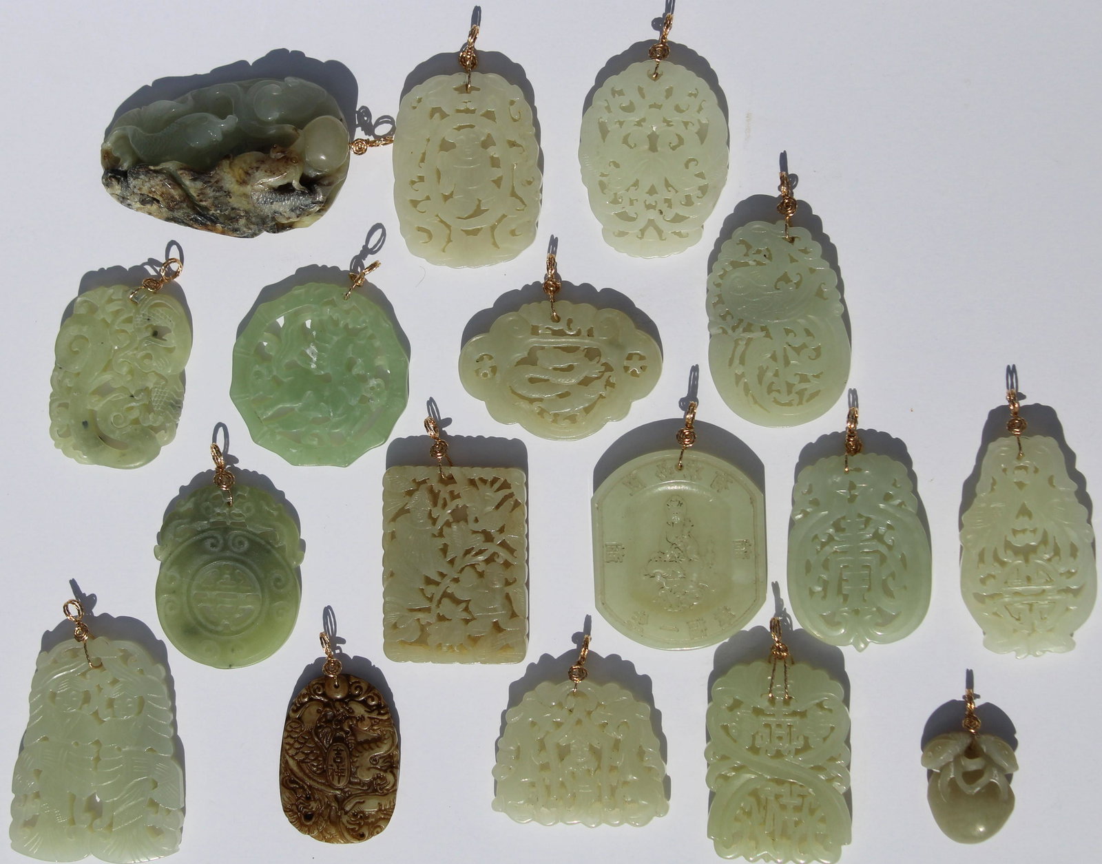 (17) Carved Chinese Jade Pendants: (17) Carved Chinese Jade Pendants with gold clasps.