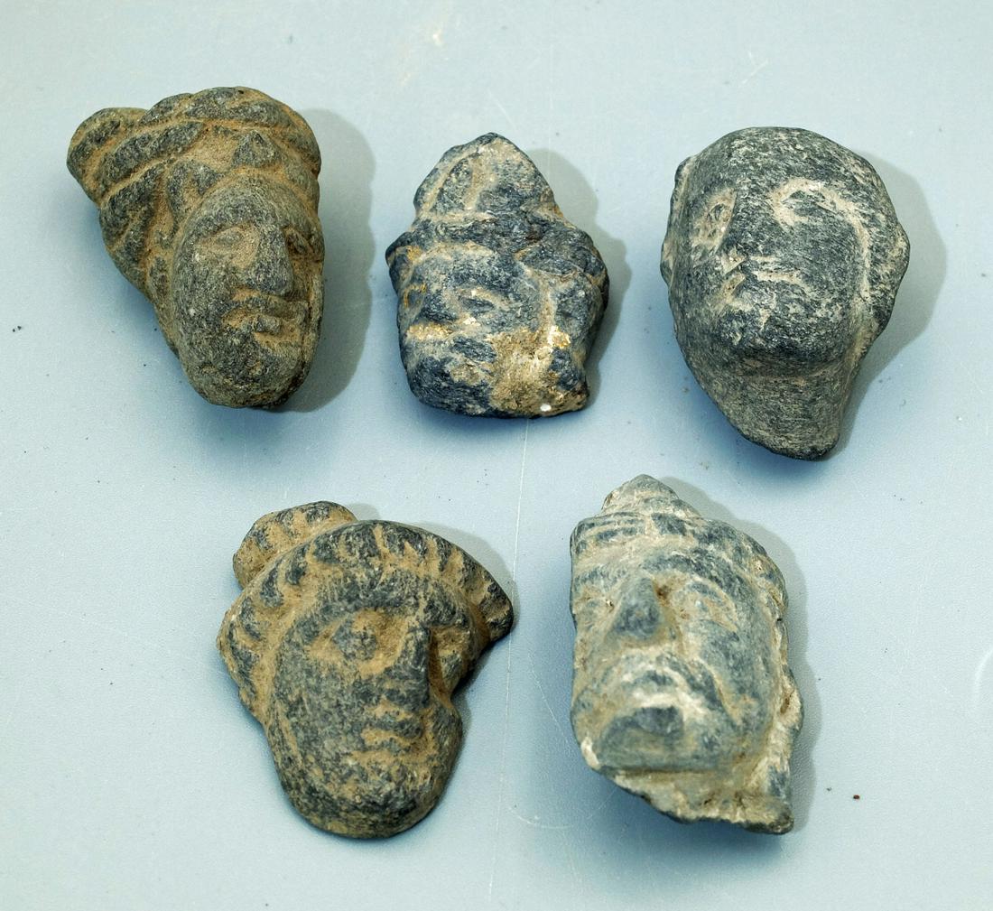 (5) Gandharan Heads - Indus Valley, 3rd - 4th C: A collection of five Gandharan stone heads from the Indus Valley, ca. 3rd - 4th Century AD. They are 1-3/8 to 1-3/4 inches high and are carved from the blue-gray schist characteristic of the region. E