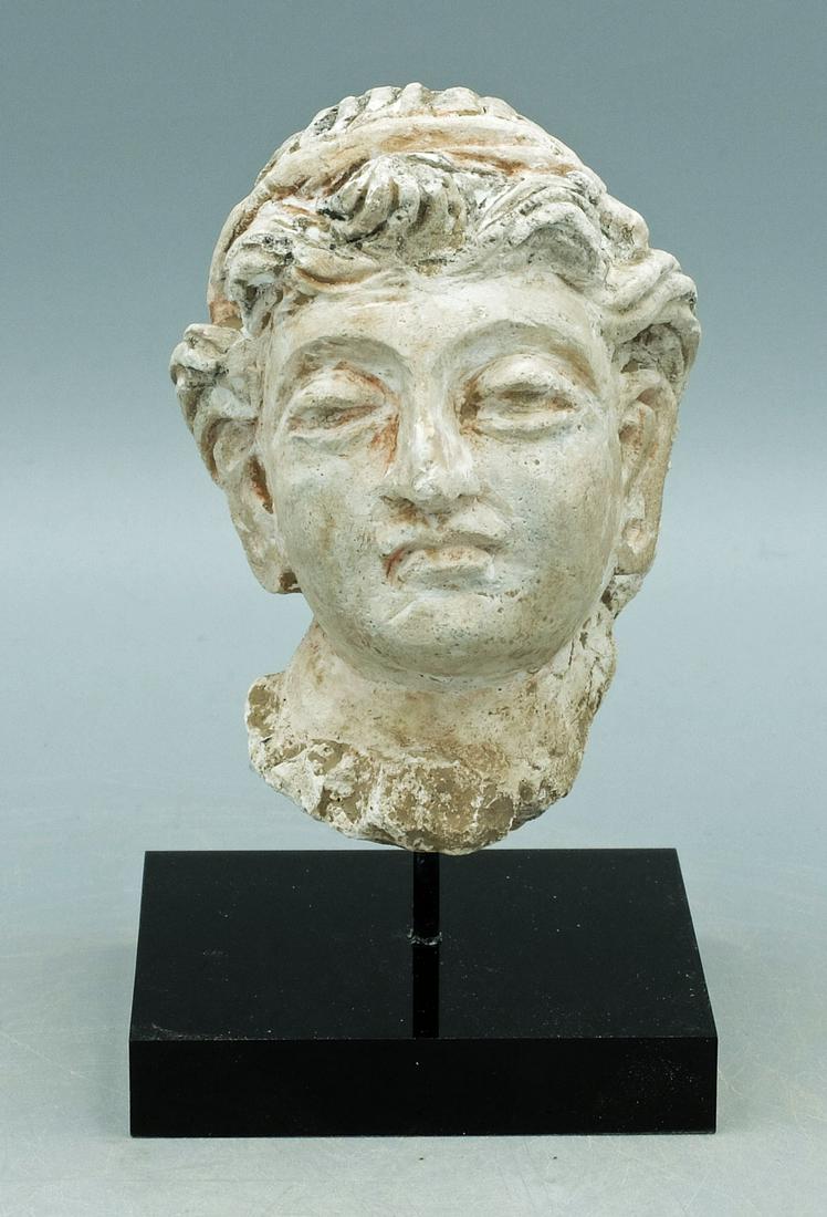 Gandharan Stucco Head - Indus Valley: A choice Gandharan stucco head from the Indus Valley, ca. 4th - 5th Century AD. This superbly detailed sculpture is 3-1/4 in high, is beautifully carved from stucco and depicts youth with his curly co