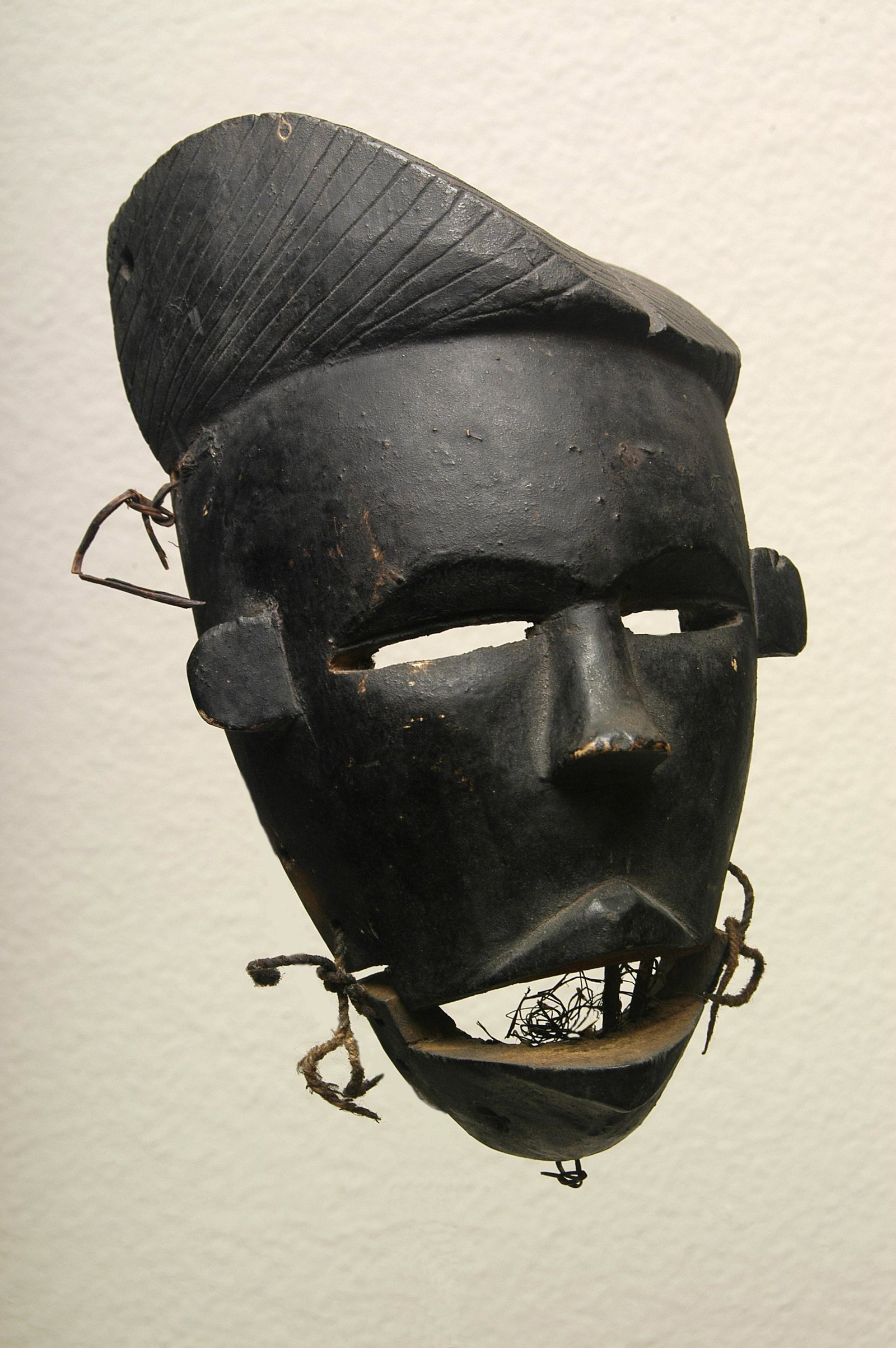 Fine Articulated Mask w/ Parted Coiffure: Early-mid 20th C. Fine articulated mask with parted coiffure Ogoni peoples Nigeria, West Africa 8"H x 5"W Wood with fiber; black painted surface In very fine condition but with expected abrasions and
