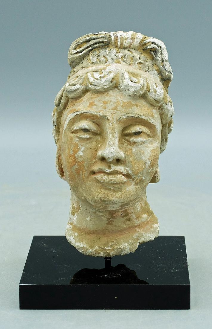 Gandharan Stucco Head - Indus Valley: A gorgeous Gandharan stucco head from the Indus Valley, ca. 4th - 5th Century AD. This superbly detailed sculpture is 4 in. high and is carved from stucco. It portrays a female member of the elite and