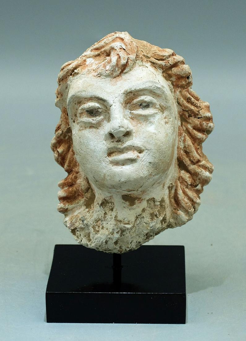 Gandharan Stucco Head - Indus Valley: A choice Gandharan stucco head from the Indus Valley, ca. 4th - 5th Century AD. This beautiful example is 3-1/4 in. high and portrays a beautiful youth with red hair. The expressive face is delicately
