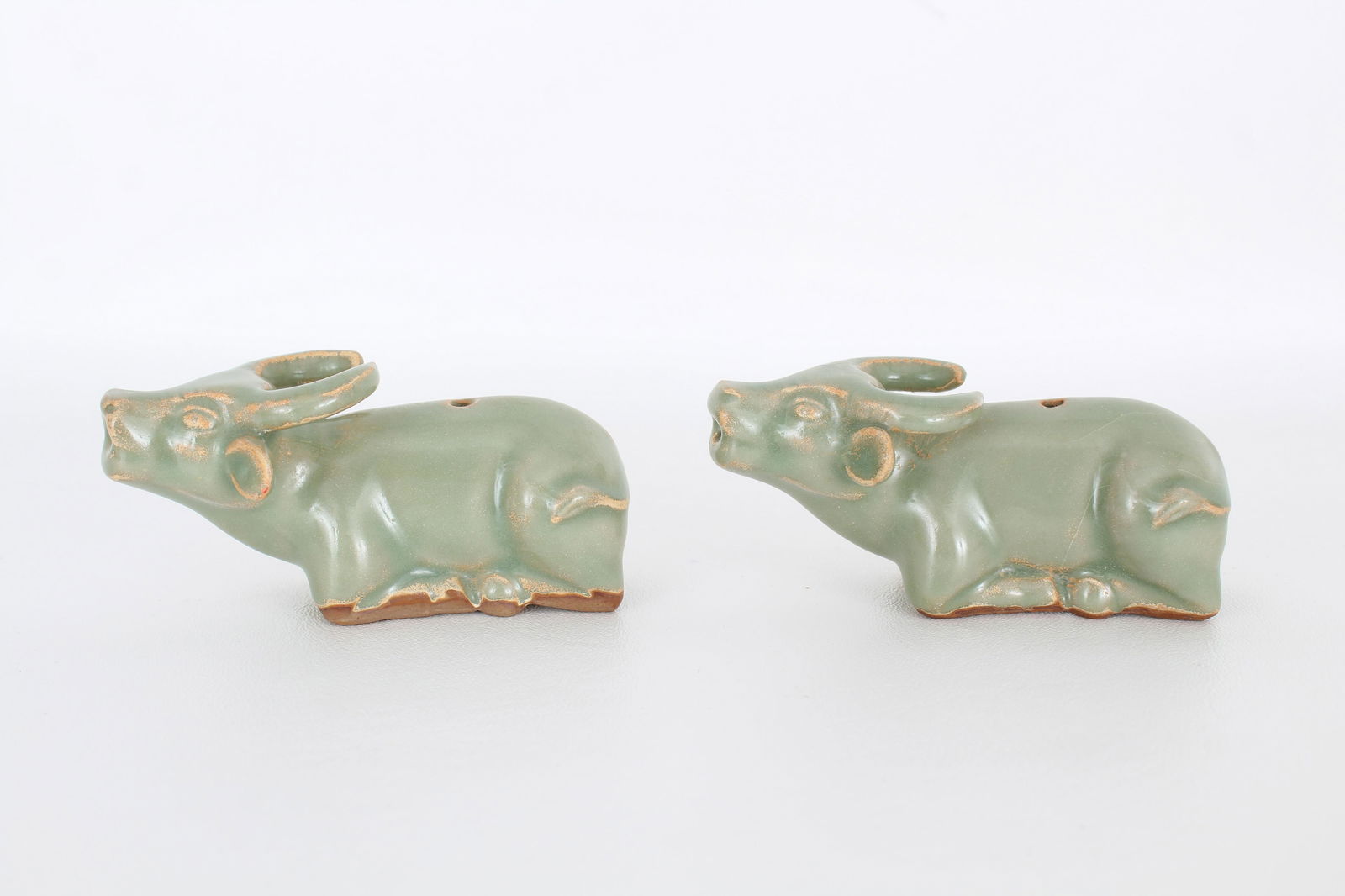 Pair, Chinese Longquan celadon figures: Pair of Chinese Longquan celadon figures of water buffalo's. Provenance: Private Montreal, Canada estate. Dimensions: 2 x 4.25 in.