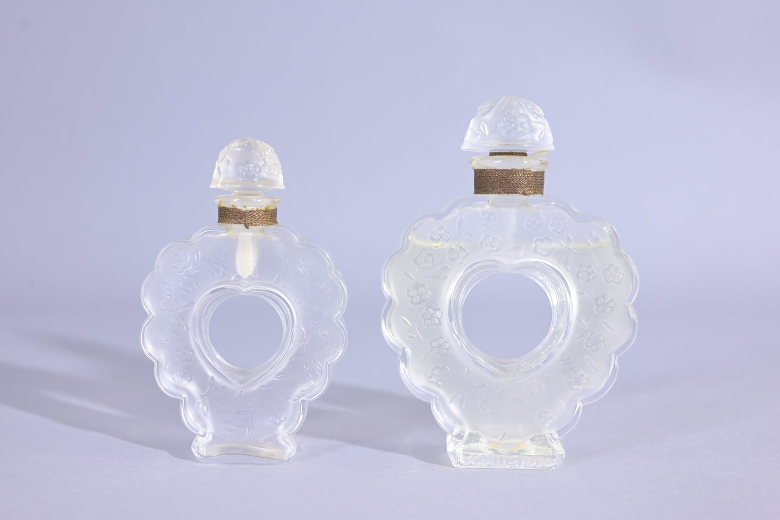 (2) Lalique Nina Ricci "Coeur Joie" Perfume Bottle: (2) Rene Lalique Nina Ricci "Coeur Joie" Perfume Bottle. Marked on the underside "Made in France by Lalique". (Lalique - 30/31) Provenance: single owner lifetime collection from Jacksonville, FL - Ent